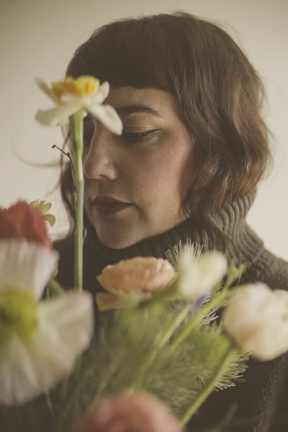 Melissa Wenzel seated in a sunlit studio surrounded by plants
